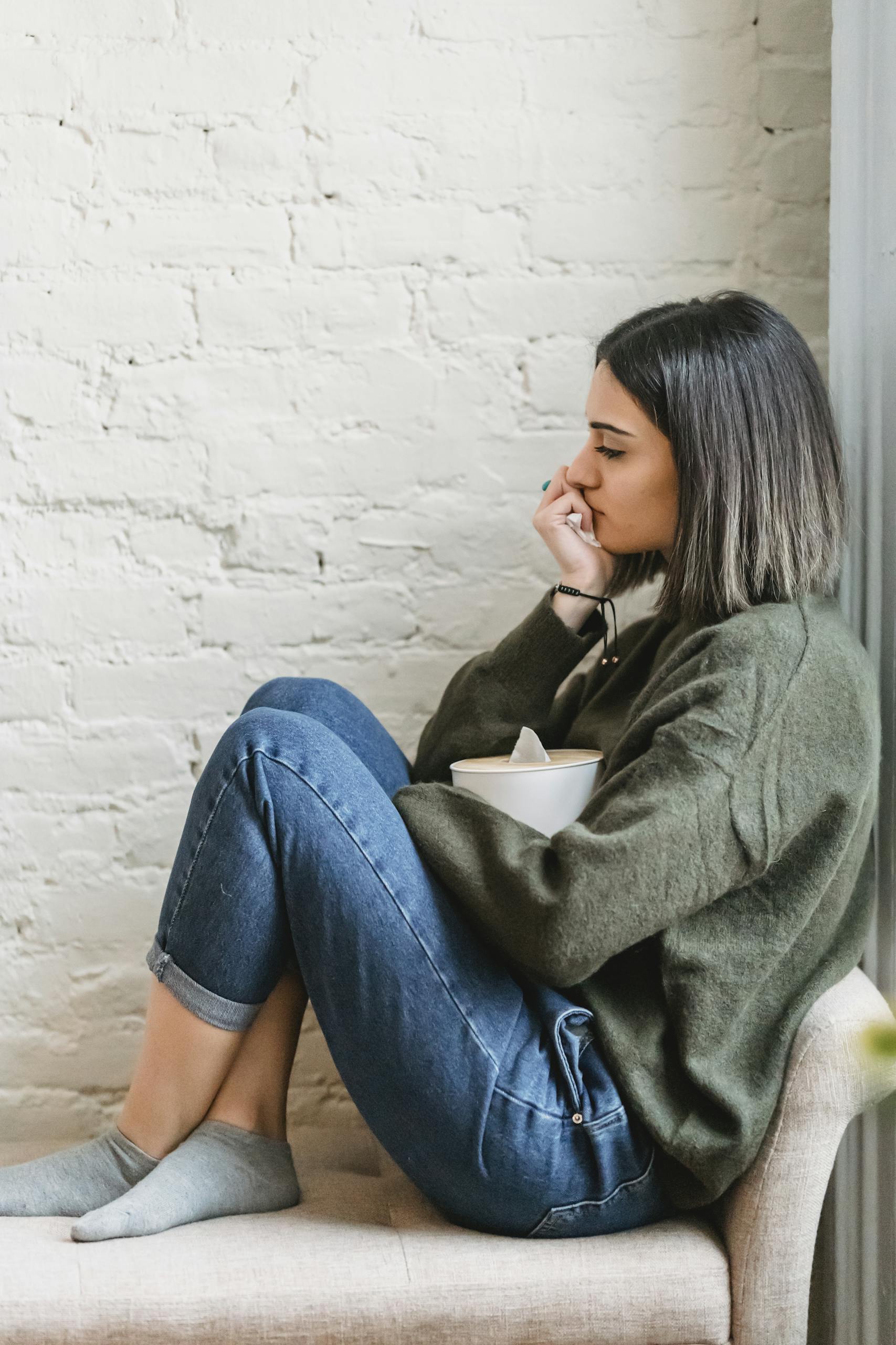 Person sitting on a couch holding a tissue box